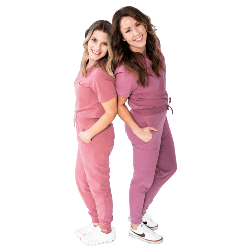 Two smiling women in pink and mauve scrubs standing back to back with hands in their pockets, surrounded by flower graphics. The friendly team behind Peekaboo Piercing in Tampa, specializing in safe medical ear piercing.