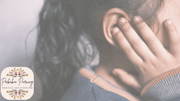 Child touching ear gently, symbolizing ear sensitivity and aftercare following medical ear piercing by Peekaboo Piercing | medical ear piercing Tampa